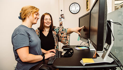 Two women looking at a computer monitor