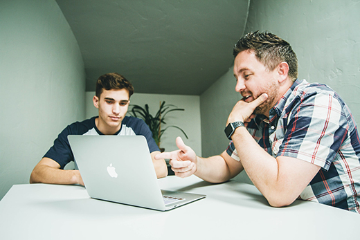 Father helping son on laptop